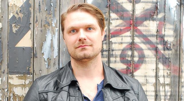 Johannes, som ønskede at få sin datter døbt, står foran grafittimur